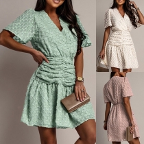 Solid Color V-neck Top with Waist Detail and Short Sleeves, Paired with a Casual Plaid Pleated Skirt